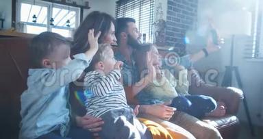 快乐的年轻白种人家庭与三个孩子挥手与朋友在智<strong>能手</strong>机视频通话在家里慢动作。